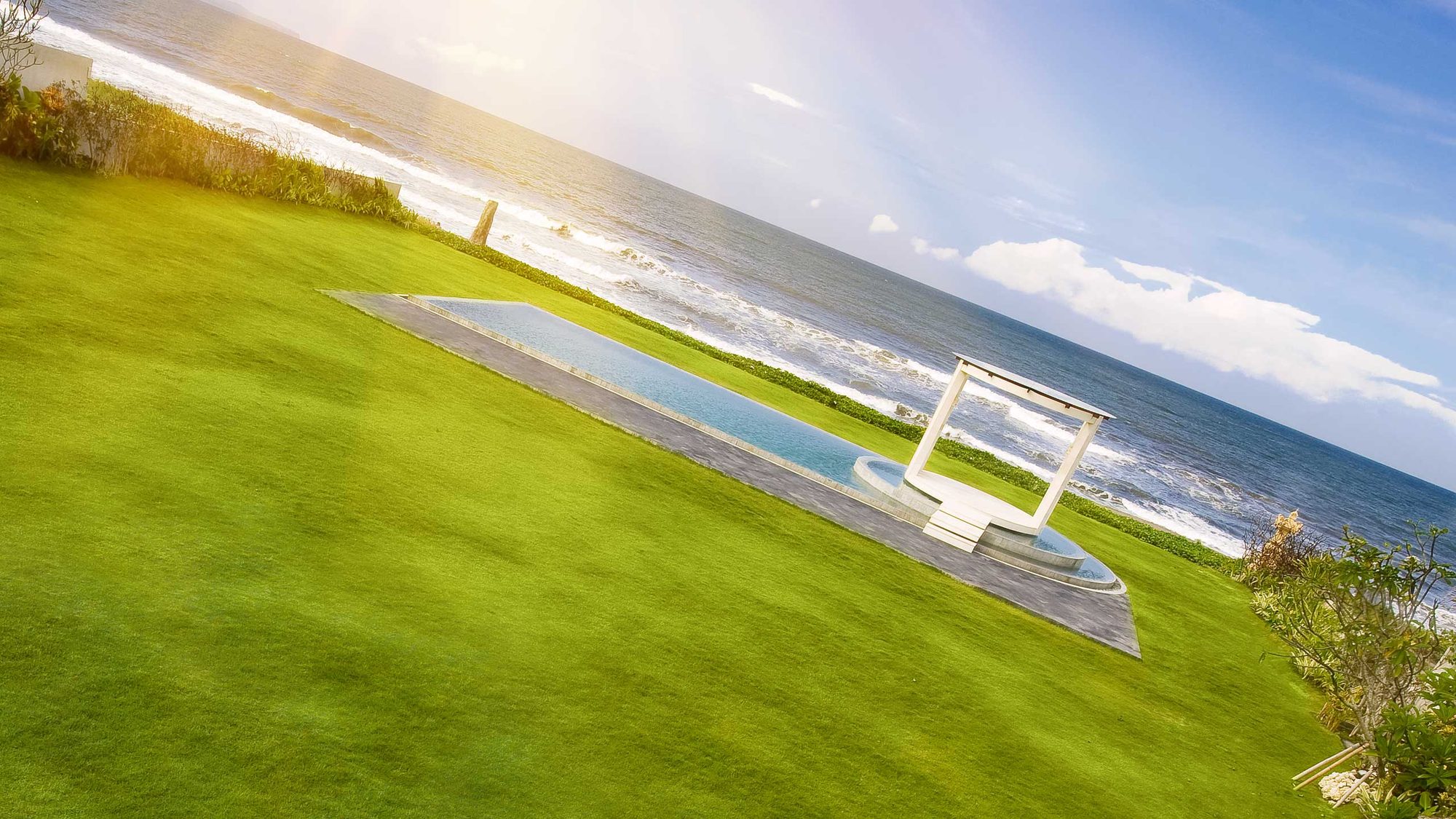 Villa Phalosa — the lawn and pool above the beach · Seminyak, Indonesia